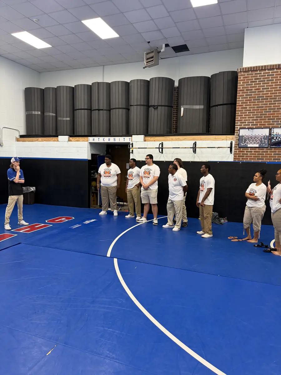 Students standing inside an athletic facility during the college tour.
